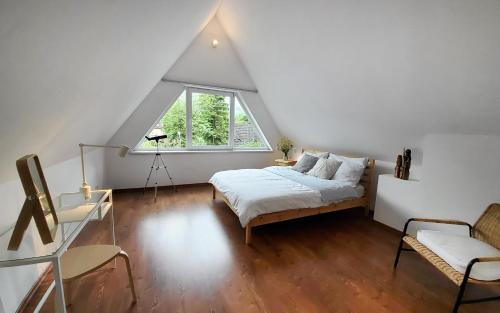 a attic bedroom with a bed and a window at Ozwa SKY in Zakopane