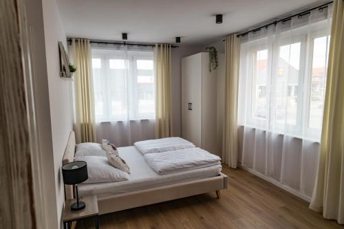 a bedroom with a bed and a large window at Apartament 2 Komfort in Słupsk