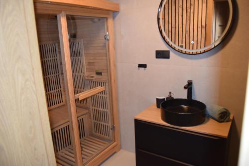 a bathroom with a sink and a shower with a mirror at Luxury Chalet Telgart in Telgárt