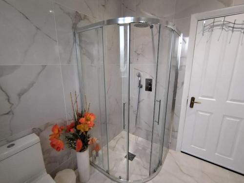 a shower in a bathroom with a vase of flowers at Wembley 2 Bed/2 Bath Modern Apt in London