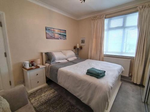a bedroom with a bed and a chair and a window at Wembley 2 Bed/2 Bath Modern Apt in London