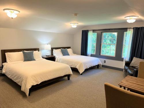 a bedroom with two beds and a couch and a chair at Westfir Lodge in Oakridge