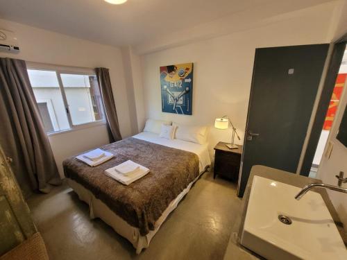 um quarto de hotel com uma cama e um lavatório em Hotel Costa Rica em Buenos Aires