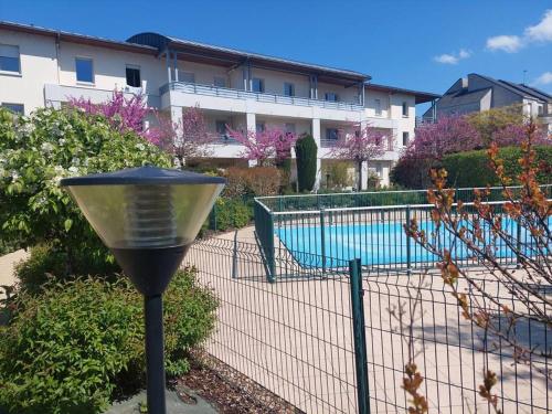 a fence with a light next to a swimming pool at Appartement 65 m² avec piscine. in Tours