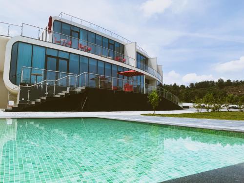 um edifício com piscina em frente a um edifício em Grapple Hotel & Spa em Carrazeda de Anciães