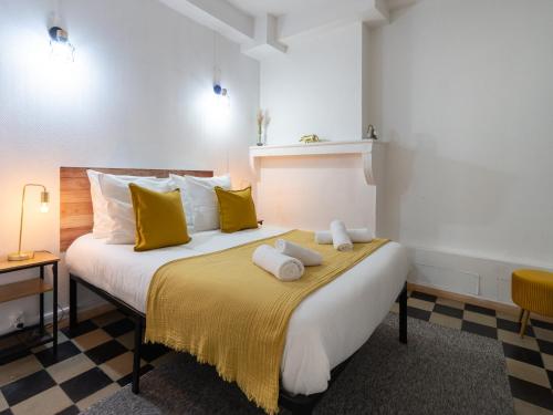 a bedroom with a large bed with yellow pillows at La petite escapade - Vienna Authentica in Vienne
