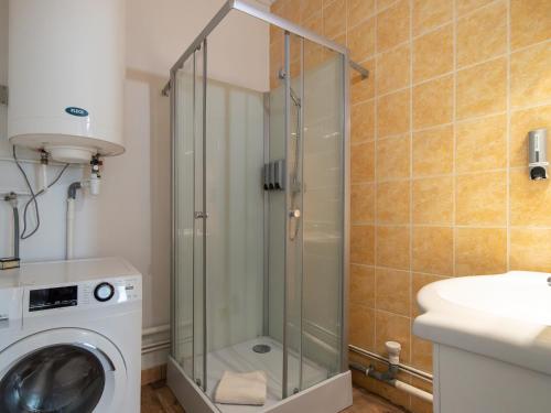 a shower stall in a bathroom with a washing machine at La petite escapade - Vienna Authentica in Vienne