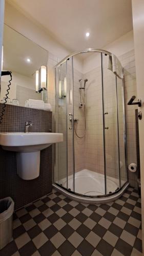 ein Bad mit einer Dusche und einem Waschbecken in der Unterkunft HOTEL de la POSTE in Esch-sur-Alzette