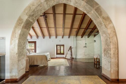 Un arco en una habitación con cama y ducha en Can Joan Capo - Adults Only en Sineu