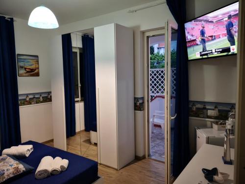 a room with a tv and a bed and a mirror at La Casa di Alfonso in Marina di Camerota