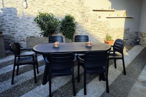 uma mesa preta e cadeiras num quarto em Grande Bilocale con giardino em Lizzano