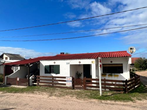 une maison blanche avec un toit rouge dans l'établissement Ave Fénix, à Aguas Dulces