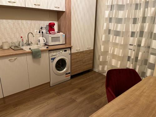een keuken met een wasmachine en een magnetron bij Serendipity Happy in Pécs