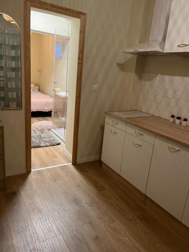 een keuken met witte kasten en een deur naar een slaapkamer bij Serendipity Happy in Pécs