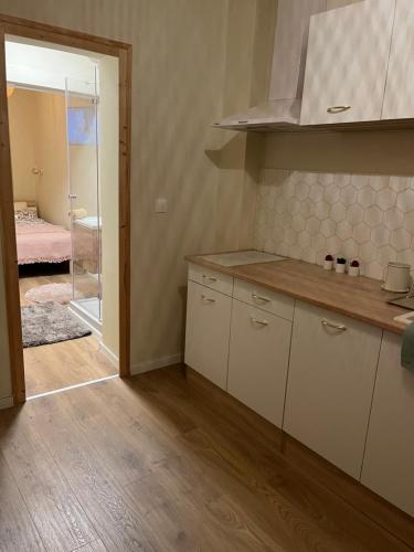 een keuken met witte kasten en een deur naar een slaapkamer bij Serendipity Happy in Pécs