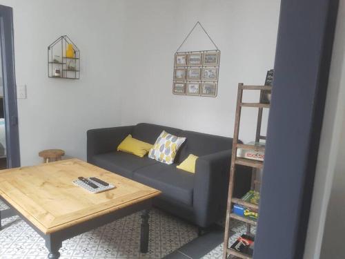 - un salon avec un canapé bleu et une table en bois dans l'établissement Maison de charme, à Saint-Riquier