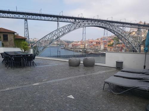 a bridge over a river with tables and chairs at Bridge It - Suites & Views in Vila Nova de Gaia
