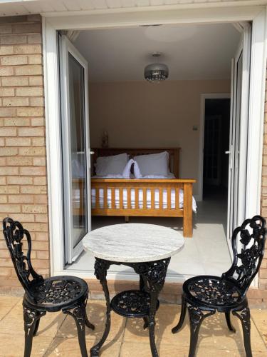 a table and two chairs on a porch with a bed at Daria in Pedmore