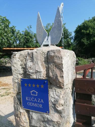a sign on a rock with a bird on it at The Forest House Krk 2 in Kras