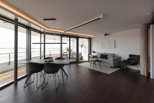 ein Wohnzimmer mit einem Tisch, Stühlen und einem Sofa in der Unterkunft Bheaven I Penthouse Premium Apartment in Bremerhaven