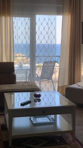 a living room with a coffee table and a view of the ocean at Guesthouse HHL - Liman ll in Ulcinj