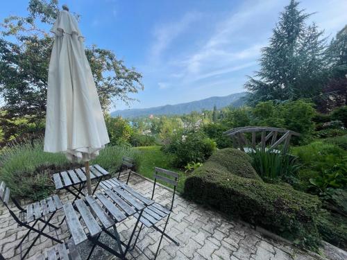 a white umbrella sitting next to two chairs and a patio at The Boathouse Apartment in Bled