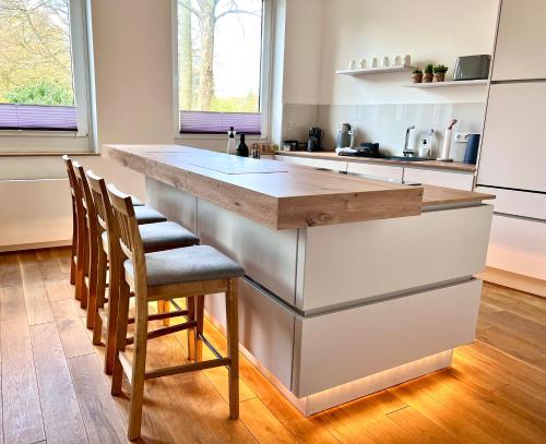 een keuken met een groot eiland in een keuken met houten vloeren bij Mi Casa 3 Zimmer geschmackvoll zentral in Bremen in Bremen