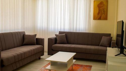 a living room with two couches and a coffee table at BELİS APART & PANSİYON in Kemer
