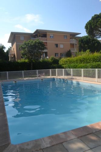 une piscine devant un immeuble dans l'établissement Appartement tranquille avec jardin et piscine, à Fréjus