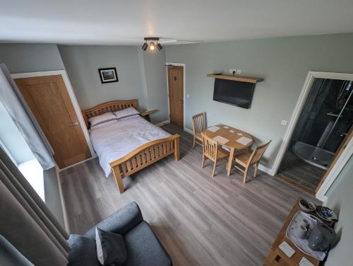 ein Schlafzimmer mit einem Bett, einem Tisch und einem Sofa in der Unterkunft Wassells House Accommodation in Cheddar