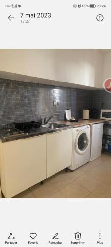une cuisine avec un évier et une machine à laver dans l'établissement Charmant T1 à 5 min à pieds du centre ville !, à Béziers