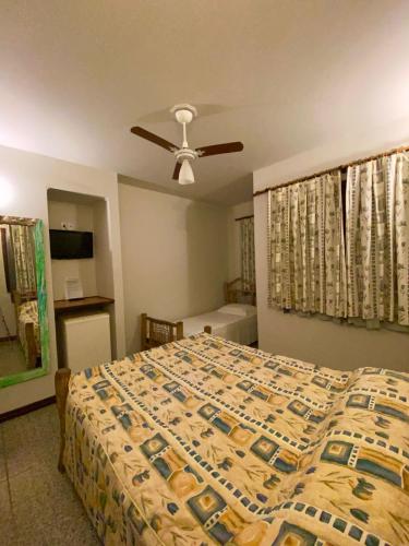 a bedroom with a bed and a ceiling fan at Pousada Só Natureza in Abraão