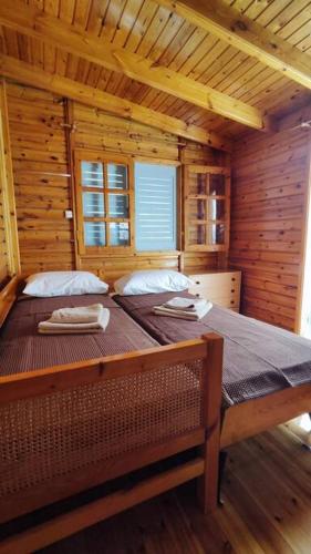 ein Schlafzimmer mit einem großen Bett in einer Holzhütte in der Unterkunft Yellow and blue relax house in Piräus