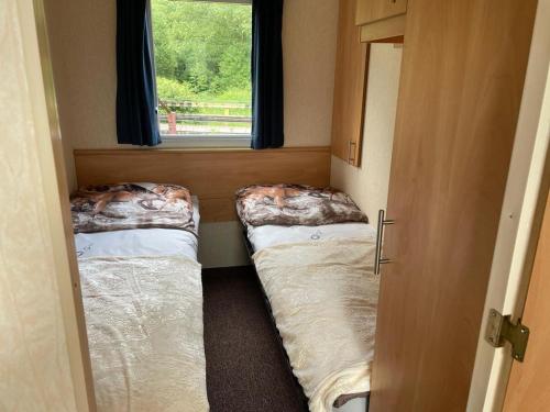 mały pokój z 2 łóżkami i oknem w obiekcie Stawy Zielona Dolina w Kudowie Zdroju