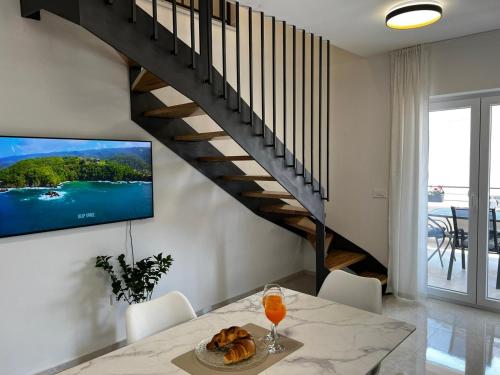 a dining room with a table and a tv on a wall at Holiday Home Bajlo in Zadar