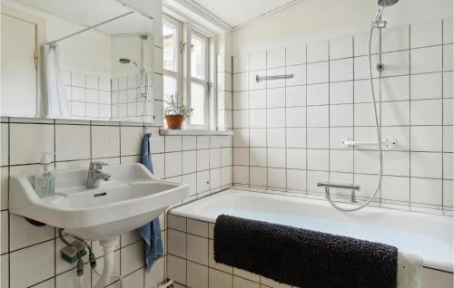a bathroom with a sink and a bath tub at Beautiful Home In Fem With Wifi in Maribo
