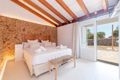 a bedroom in a villa with a bed and a window at Alcotx Country Club in Es Mercadal