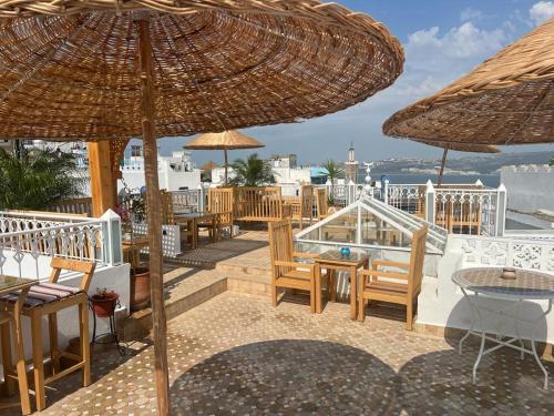 a patio with tables and chairs and umbrellas at Kasba blanca in Tangier