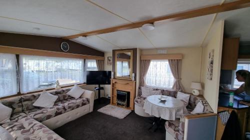 a living room with a couch and a table at Millfields 6 berth caravan MAX 4 ADULTS Bob family's only and lead person must be over 30 in Ingoldmells