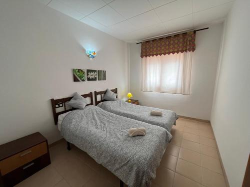 2 camas individuales en un dormitorio con ventana en Casa Gonia, en Riumar
