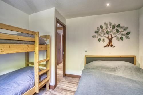 a bedroom with two bunk beds and a tree mural on the wall at Carline in Morillon