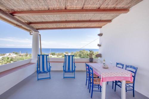 una mesa y sillas en un balcón con vistas al océano en Case Vacanza Gia.no, en Stromboli