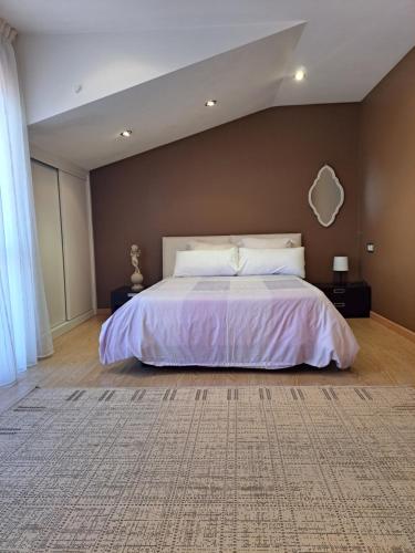1 dormitorio con 1 cama grande con colcha blanca en Casa privada centrica, en Villanueva de Arosa