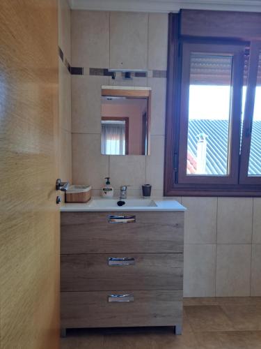 ein Bad mit einem Waschbecken und einem Spiegel in der Unterkunft Casa privada centrica in Vilanova de Arousa