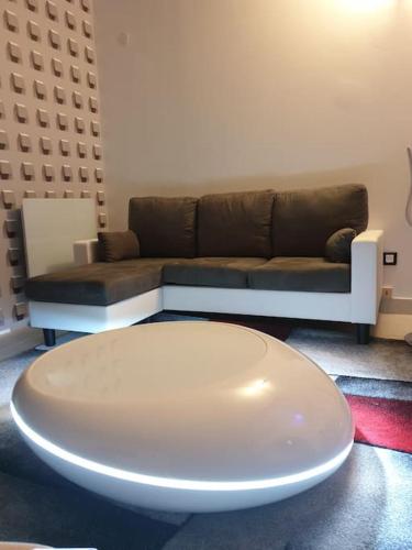 ein Wohnzimmer mit einem Sofa und einem weißen Tisch in der Unterkunft Dieppe Love-amour in Dieppe