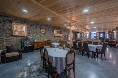a dining room with tables and chairs in a building at SVANETI in Lentekhi