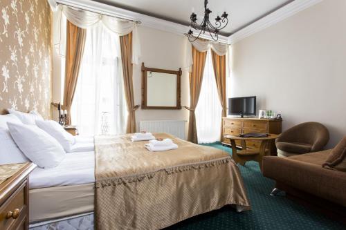 a hotel room with a bed and a chair at Abella Suites & Apartments by Artery Hotels in Krakow