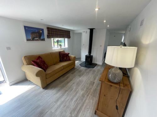 a living room with a couch and a lamp at Shepherds Gate at The Royal Oak Much Marcle in Preston