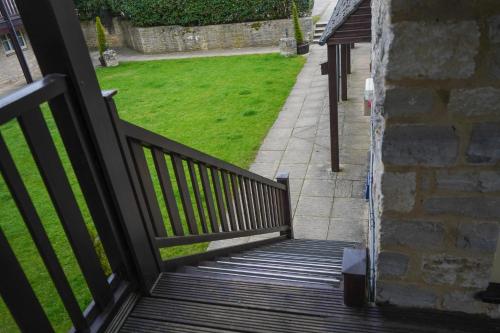 a balcony with a wooden railing and a lawn at The Bird In Hand Inn, Witney in Witney
