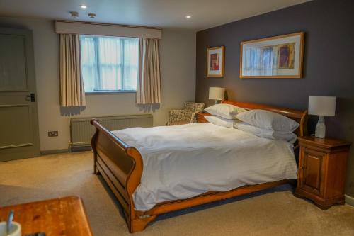 een slaapkamer met een groot bed en een raam bij The Bird In Hand Inn, Witney in Witney